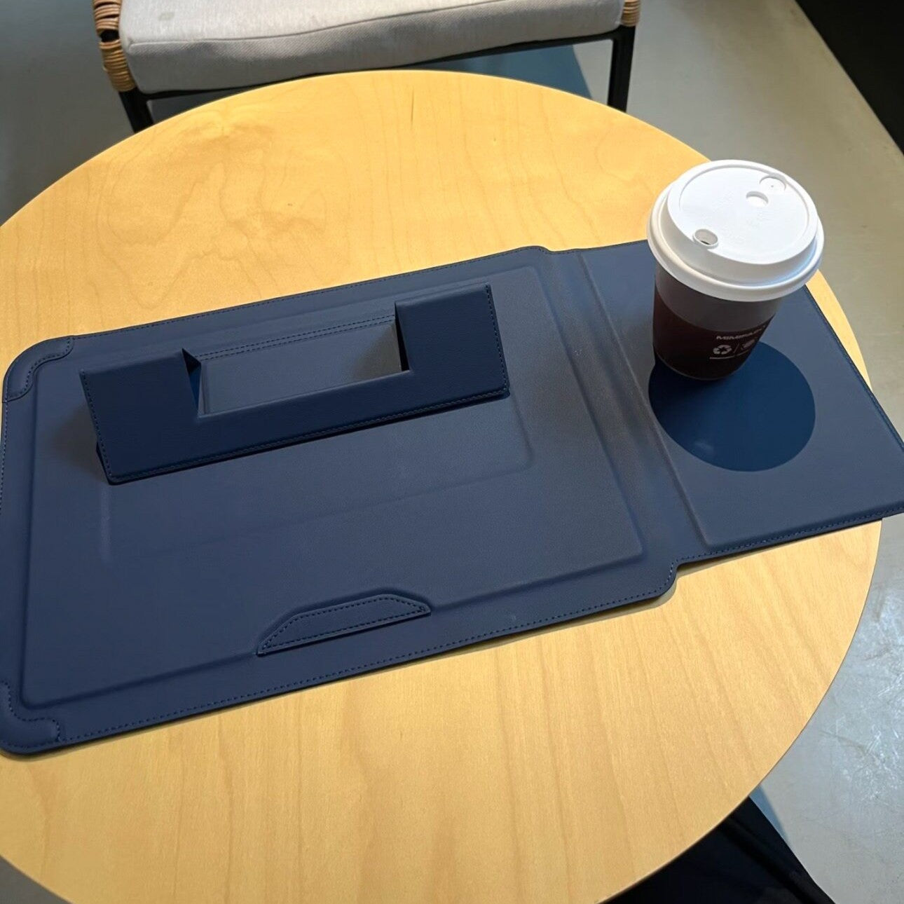 Laptophoes naast een laptop op een bureau